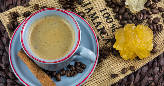 Cup of coffee with coffee beans and a gummy bear on a textured surface